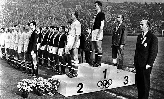 Novák Dezsõ, aanvoerder van de goudwinnende Hongaarse ploeg, op het Olympisch podium in 1964. 