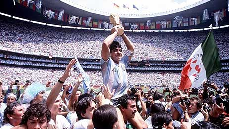 Diego Maradona mag, op de schouders gedragen, de FIFA Wereldbeker omhoog steken. 