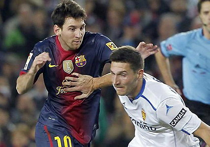 Ádám in strijd met Lionel Messi tijdens een wedstrijd tussen FC Barcelona en Real Zaragoza in september 2013.