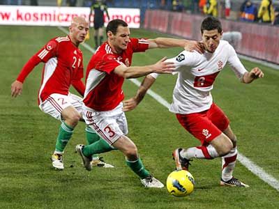 Varga (links) en Vanczák Vilmos tegen Robert Lewandowski tijdens een wedstrijd van Hongarije tegen Polen op 15-11-2011.