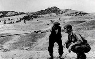 Een Siciliaanse boer toont een Amerikaans soldaat de door de Duitsers genomen weg, Sicilië, 4 of 5 augustus 1943. 