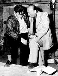 n bespreking met Elvis Presley bij het draaien van de film 'King Creole' (1958).