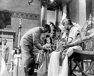 Michael Curtiz samen met Anitra Stevens (Nefertiti) en Michael Wilding (Akhnaton) 'The Egyptian' (1954).
